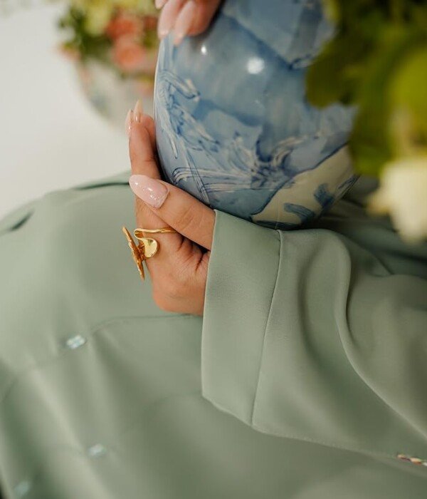 Beautiful details and premium fabric quality Premium Korean Nida fabric detail on the Sage Green Abaya sleeve with elegant gold accessories